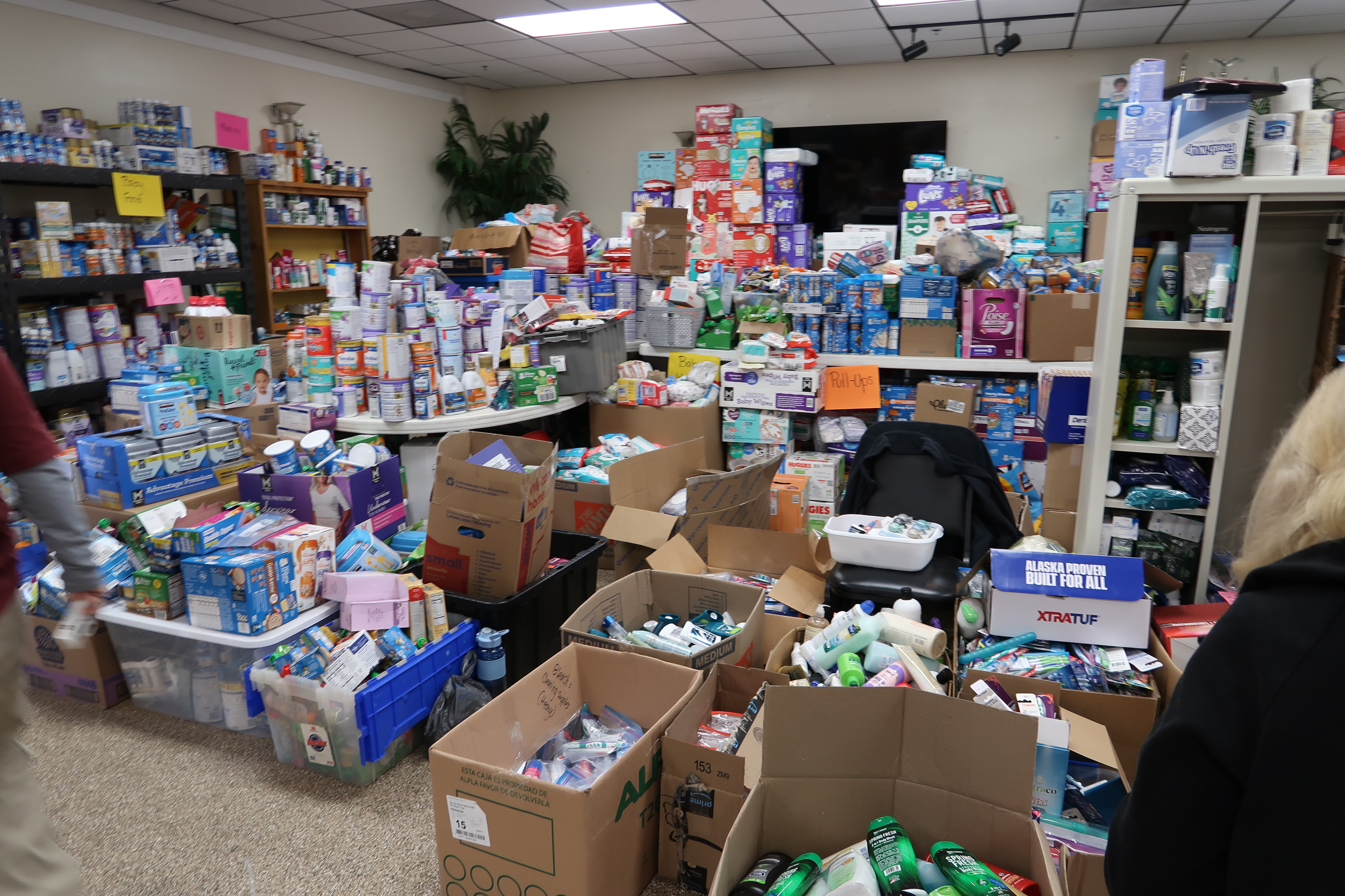 Image of room with diapers, water, cleaning supplies and more stacked high