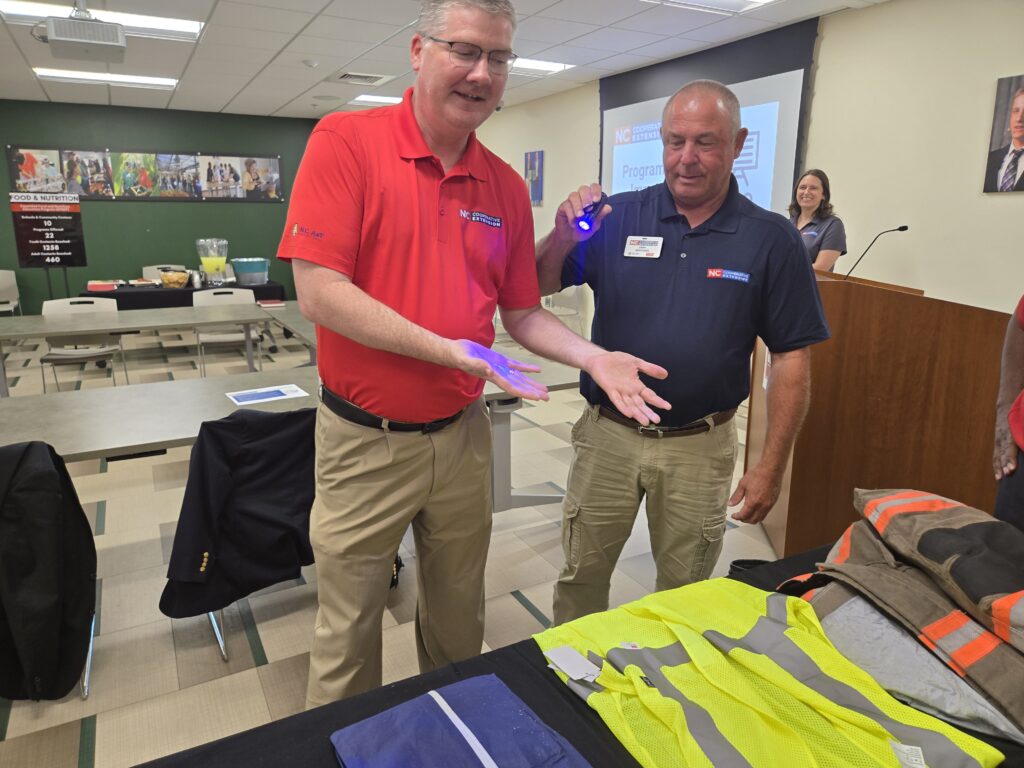 CALS Dean Garey Fox gets a hands-on look at field safety gear with Daryl Anderson, Extension agriculture agent in Wayne County.